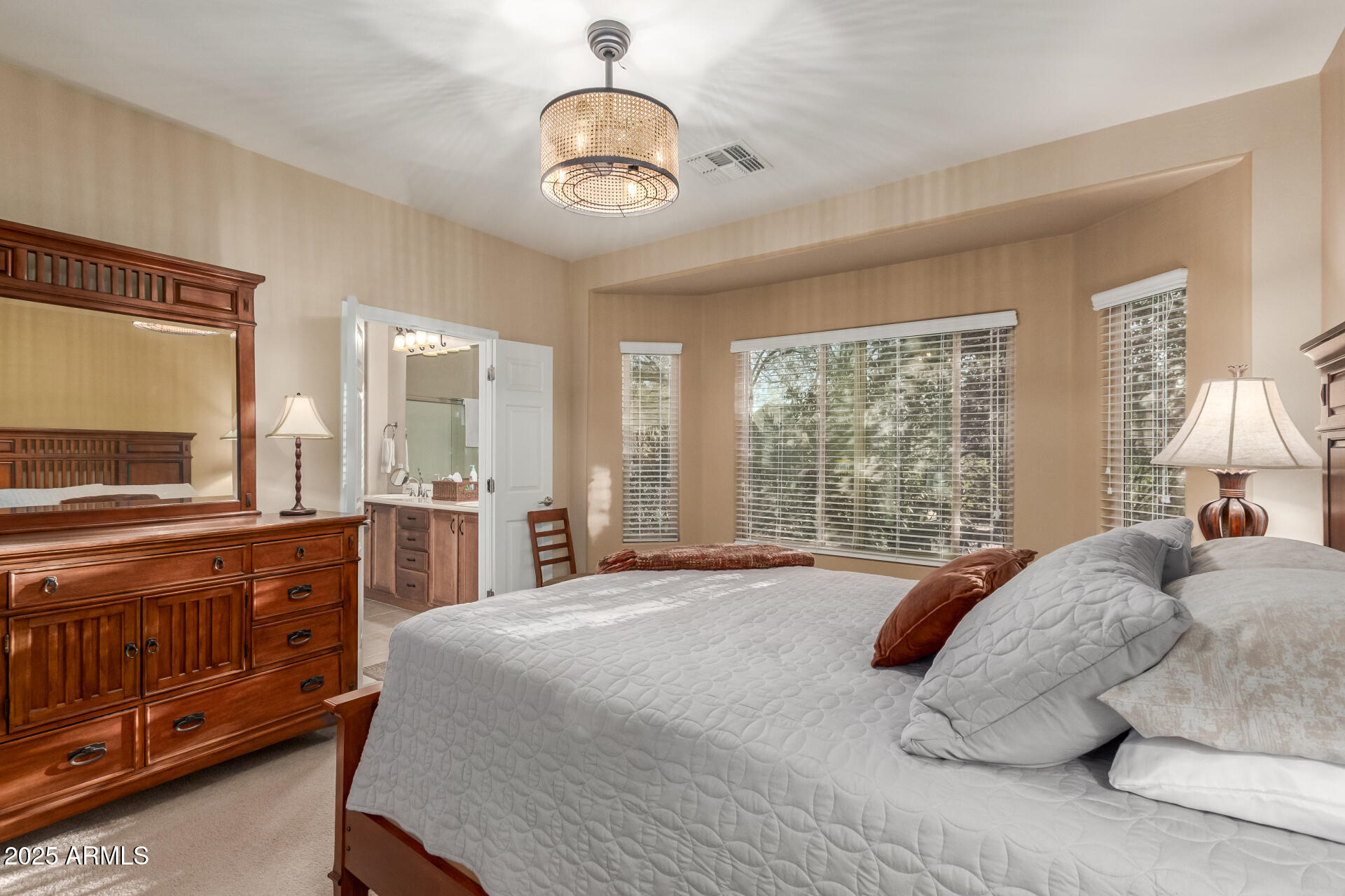6573 West Mockingbird Way Florence, AZ 85132 - Photo 12 of 36 a spacious bedroom with a large bed and a chandelier