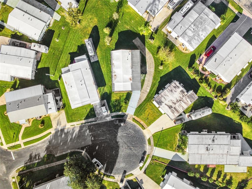 an aerial view of a house with a yard and greenery