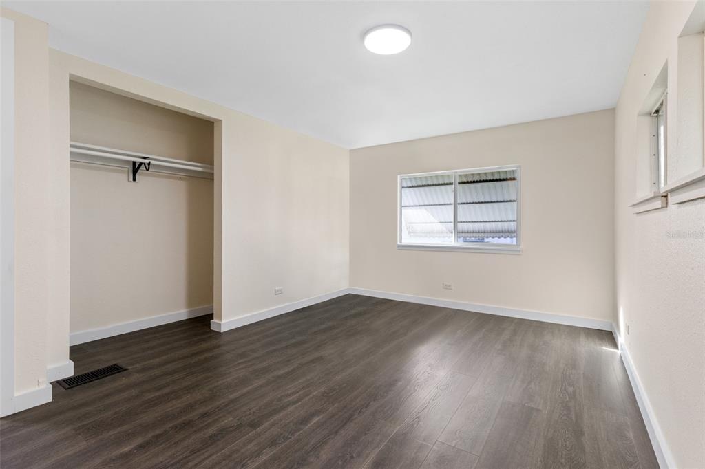 29129 Johnston Road, Unit 2626 Dade City, FL 33523 - Photo 11 of 31 an empty room with wooden floor closet and windows