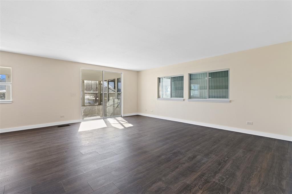 29129 Johnston Road, Unit 2626 Dade City, FL 33523 - Photo 10 of 31 a view of an empty room with wooden floor and a window