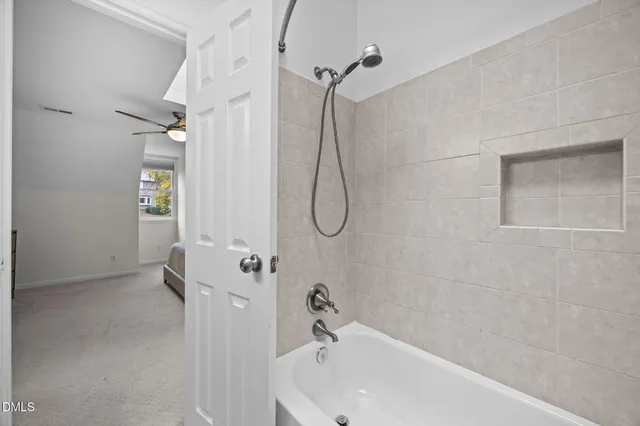 a bathroom with a white bath tub sitting next to a window