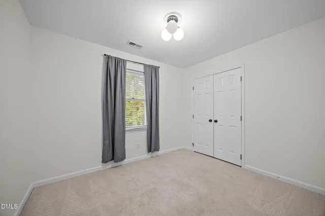 a view of a room with a ceiling fan and window