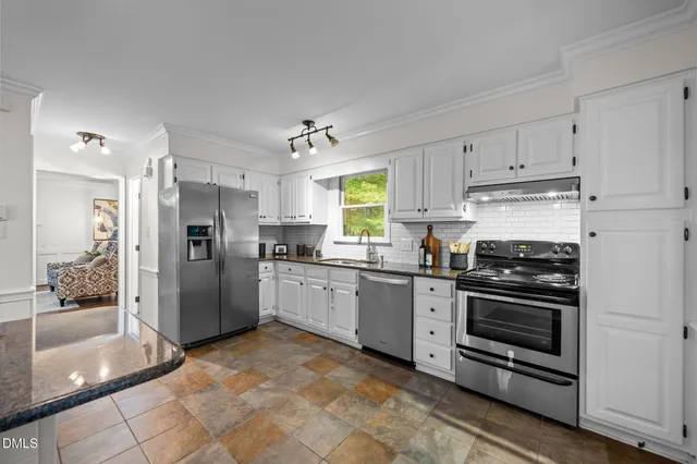 a kitchen with stainless steel appliances granite countertop a refrigerator and a stove top oven