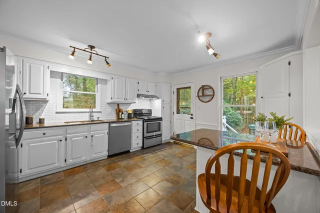 a kitchen with sink refrigerator and window