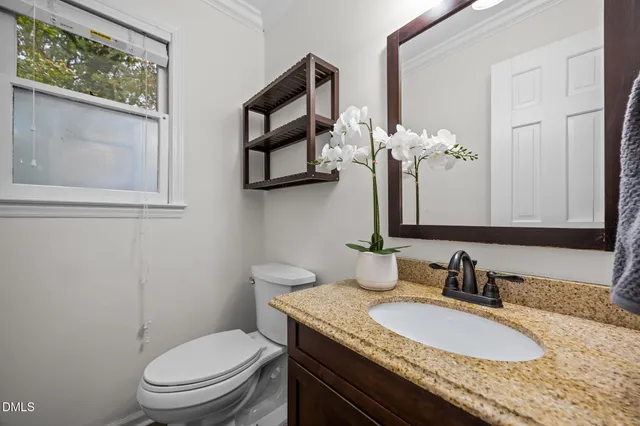 a view of staircase with lots of frames on wall and wooden floor