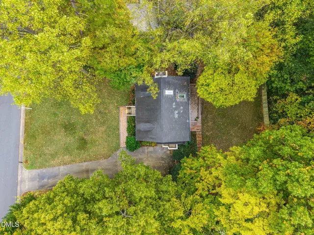 a view of a house with backyard and trees