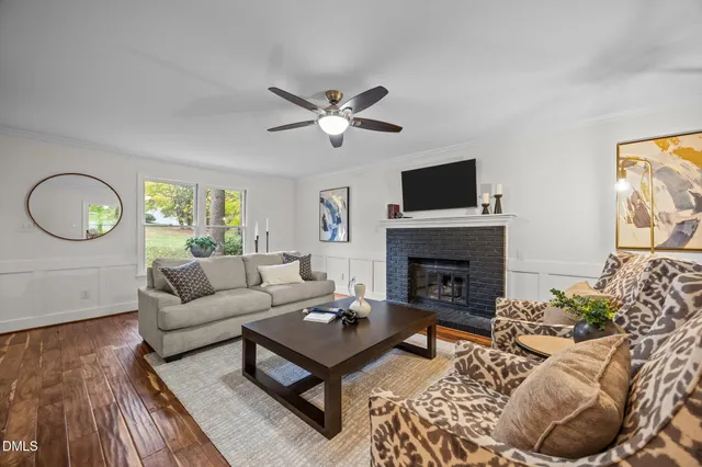 a living room with furniture a fireplace and a flat screen tv