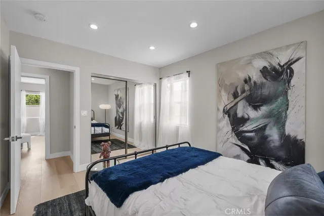 a bedroom with a bed and wooden floor