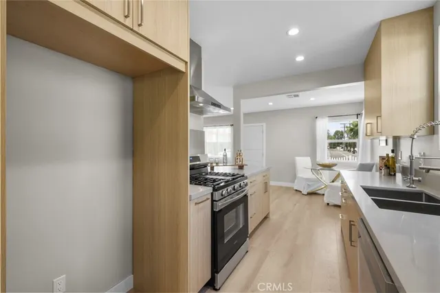 a kitchen with a sink a counter top space stainless steel appliances and cabinets