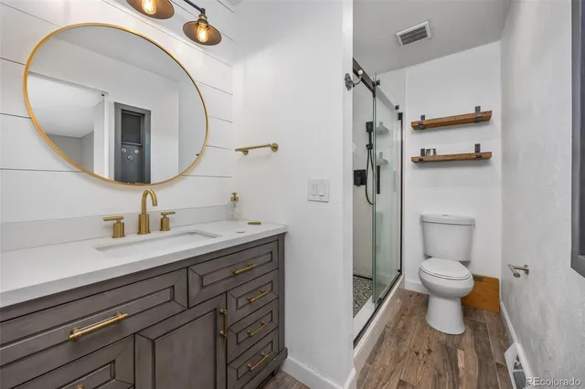 a bathroom with a sink a toilet and shower