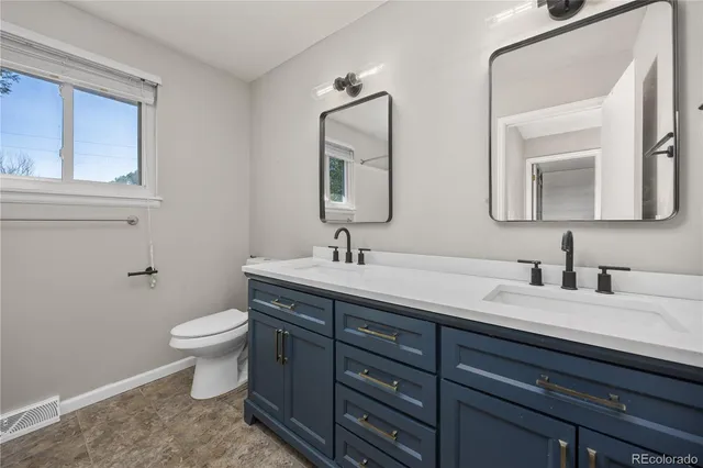 a bathroom with a toilet sink and mirror