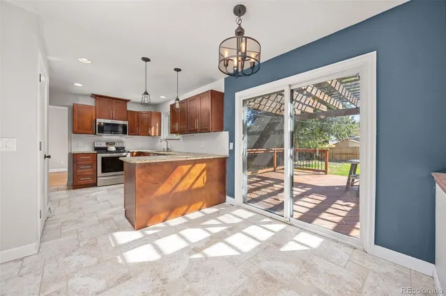a view of kitchen with granite countertop cabinets and refrigerator