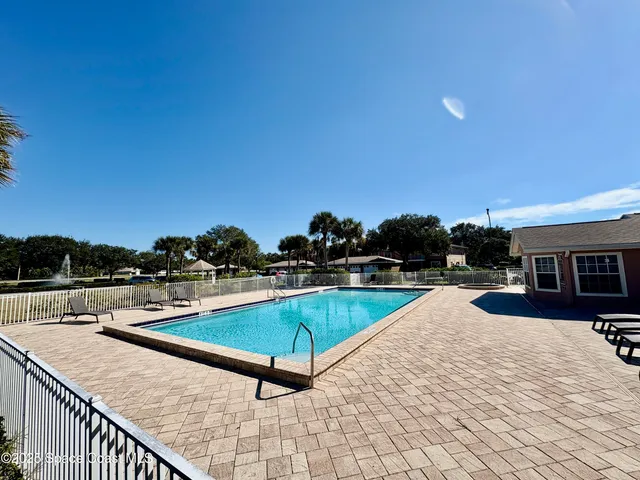 a swimming pool with outdoor seating and barbeque