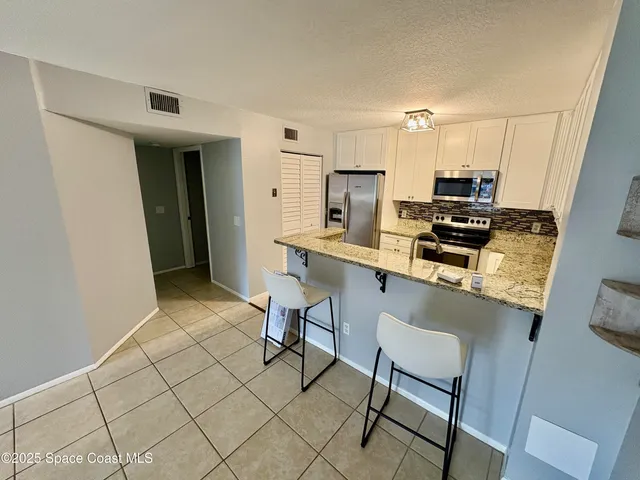 a kitchen with stainless steel appliances a refrigerator and a stove top oven