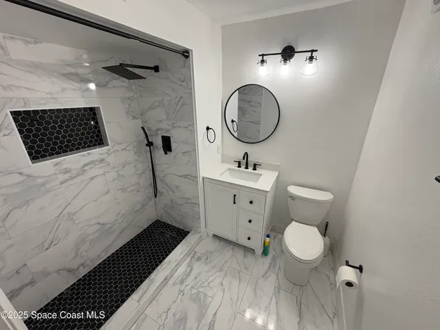 a bathroom with a toilet a sink and a mirror