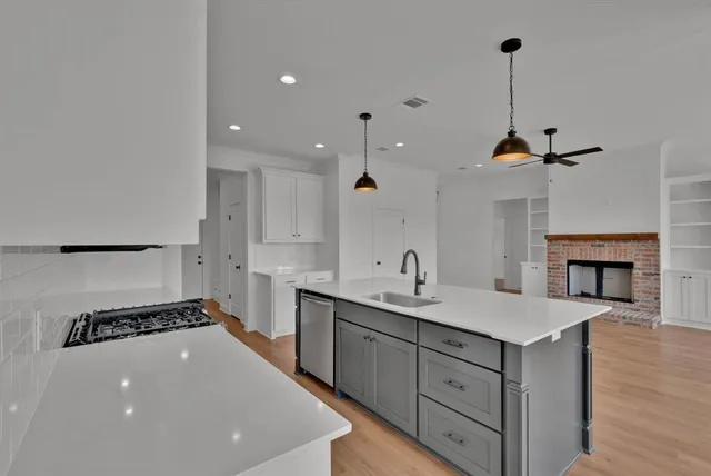 a kitchen with stainless steel appliances granite countertop a stove a sink and a microwave