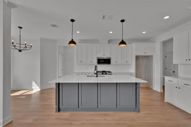a kitchen with kitchen island a sink stainless steel appliances and cabinets