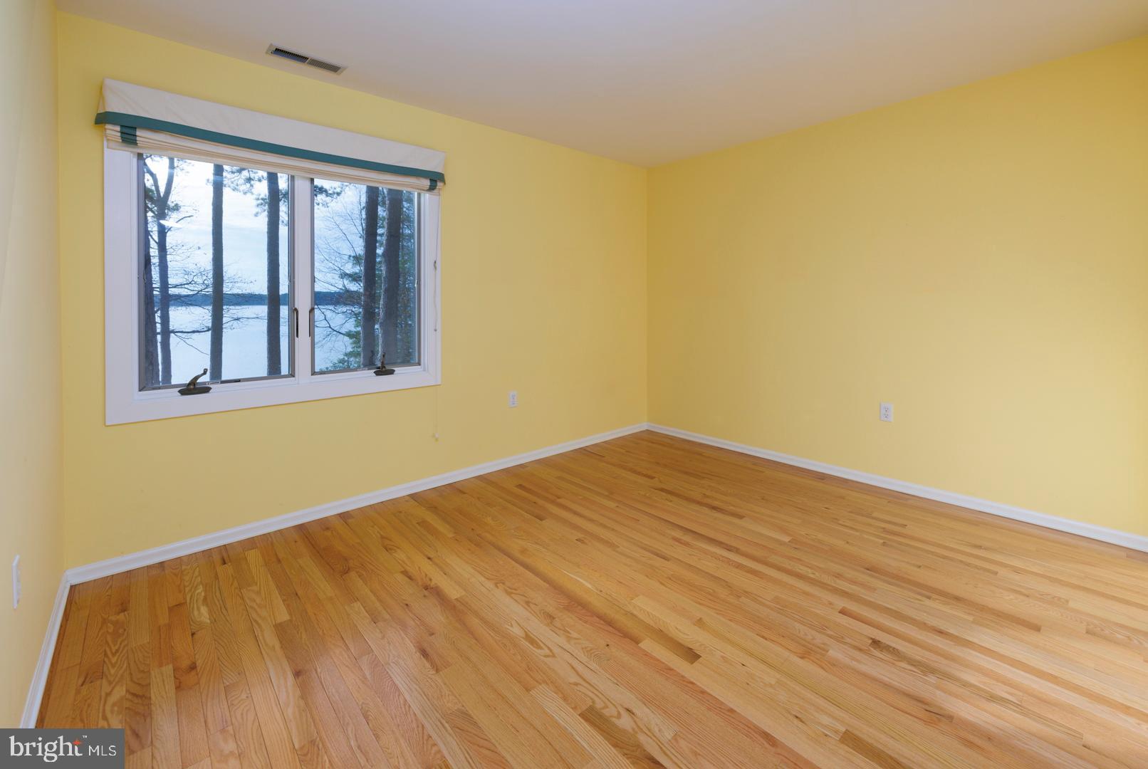7930 Church Neck Road St. Michaels, MD 21663 - Photo 33 of 41 a view of empty room with wooden floor and fan