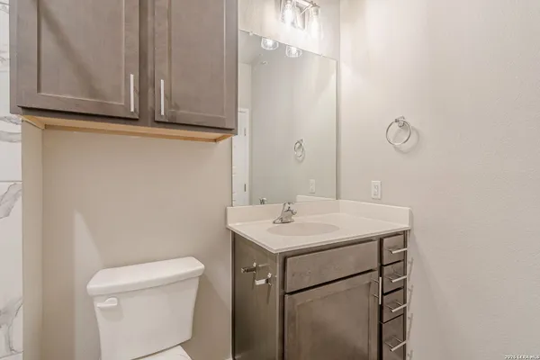 a bathroom with a sink a toilet and a mirror