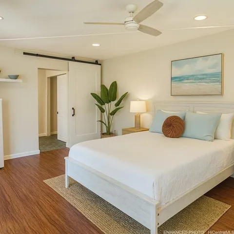a bedroom with a bed and wooden floor