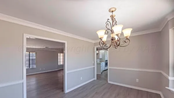 a view of a room with wooden floor and chandelier