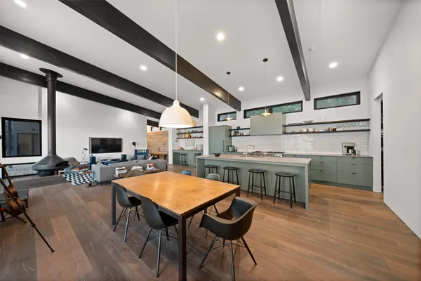 a kitchen with a table chairs stove and wooden floor