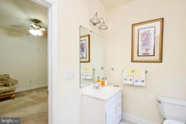 a bathroom with a toilet a sink a mirror and shower