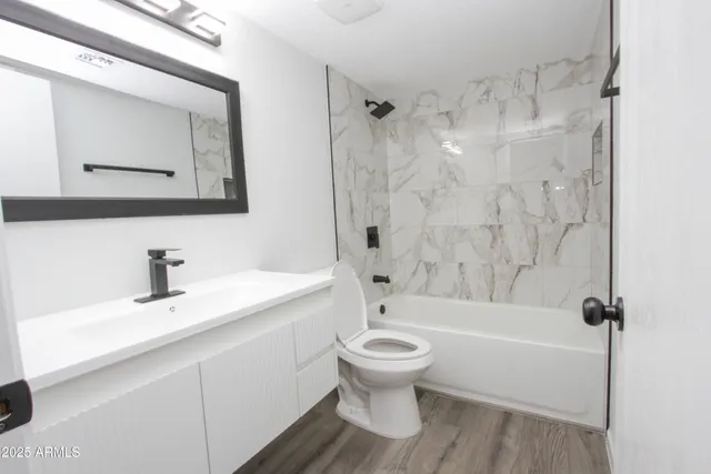 a bathroom with a bathtub toilet sink vanity and mirror
