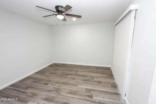 a view of a room with wooden floor and a ceiling fan
