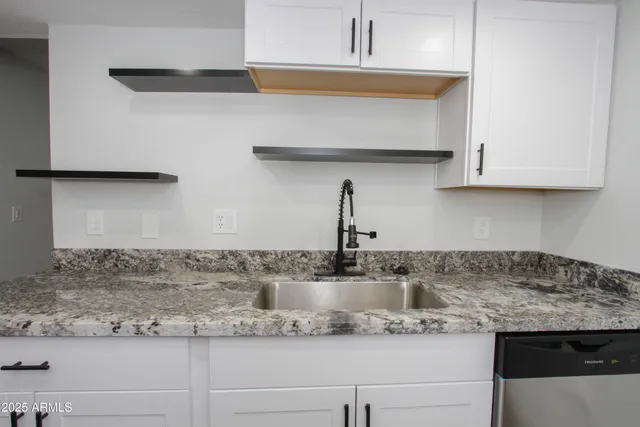 a kitchen with stainless steel appliances granite countertop a sink a stove and cabinets