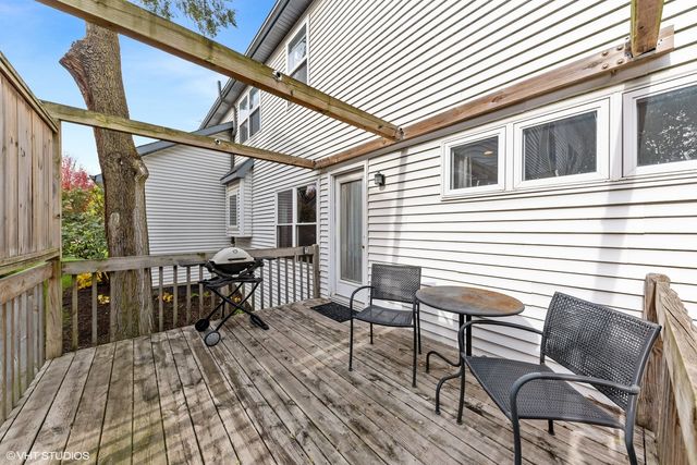 a view of a patio with table and chairs with wooden floor and fence