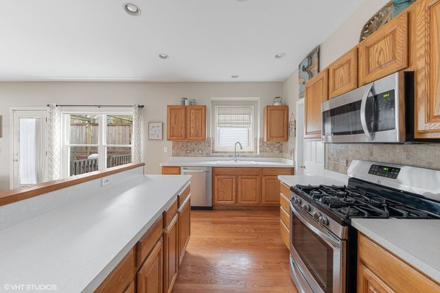 a kitchen with stainless steel appliances a sink stove and cabinets