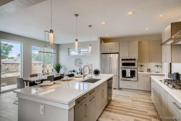 a kitchen with counter top space a sink stainless steel appliances and windows