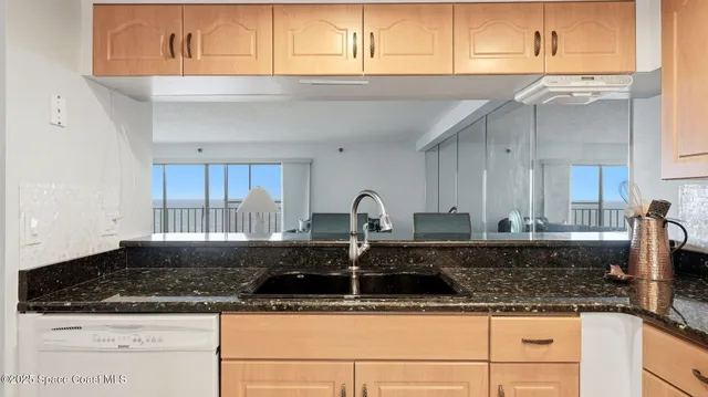 a kitchen with granite countertop a sink and a stove