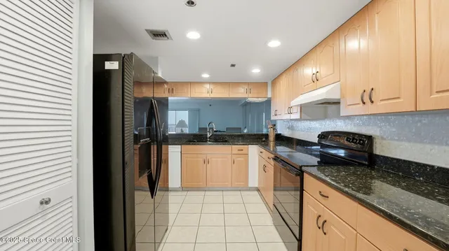 a kitchen with stainless steel appliances granite countertop a refrigerator and a stove