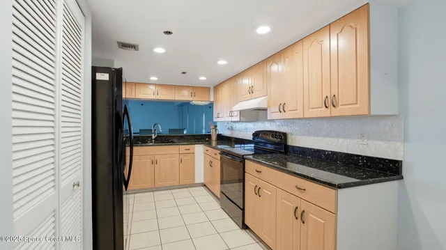 a kitchen with granite countertop white cabinets and stainless steel appliances