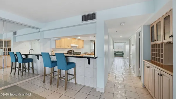 a kitchen with stainless steel appliances kitchen island granite countertop a table chairs sink and cabinets