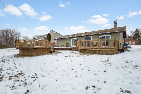 a front view of a house with a yard and covered with snow