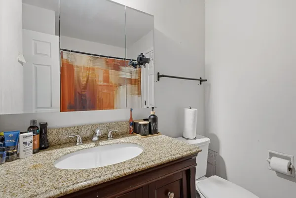 a bathroom with a granite countertop sink and a mirror