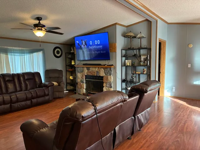 a living room with stainless steel appliances kitchen island granite countertop furniture and wooden floor