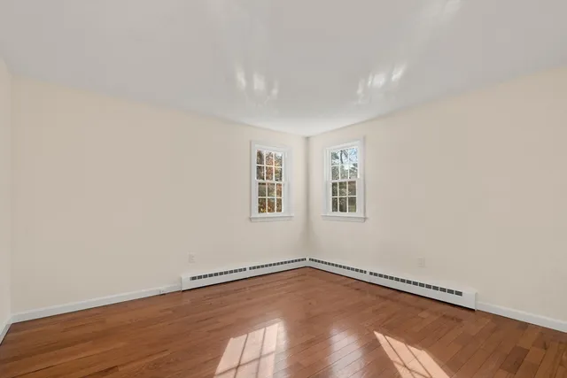 a view of a room with wooden floor and windows