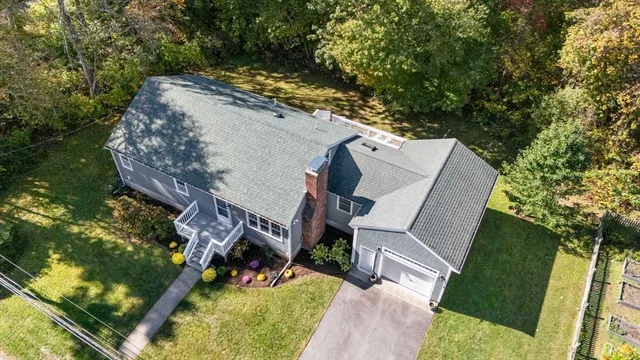 a view of a house with a big yard and large trees