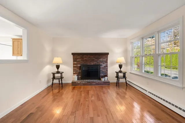 wooden floor fireplace and windows in an empty room