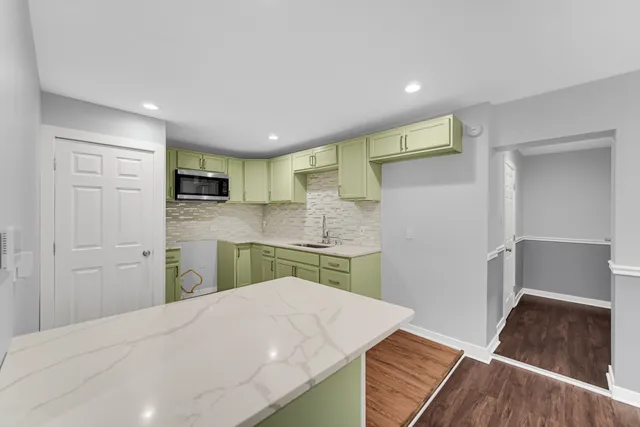 a kitchen with a refrigerator and a stove top oven