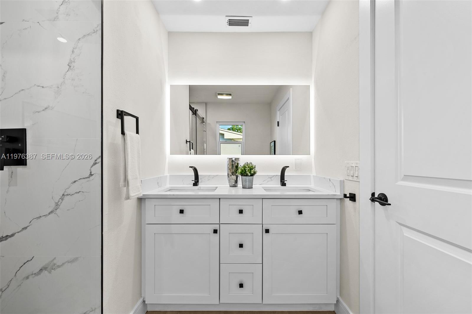 105 12th Street Southwest Ruskin, FL 33570 - Photo 27 of 89 a bathroom with a double vanity sink and mirror