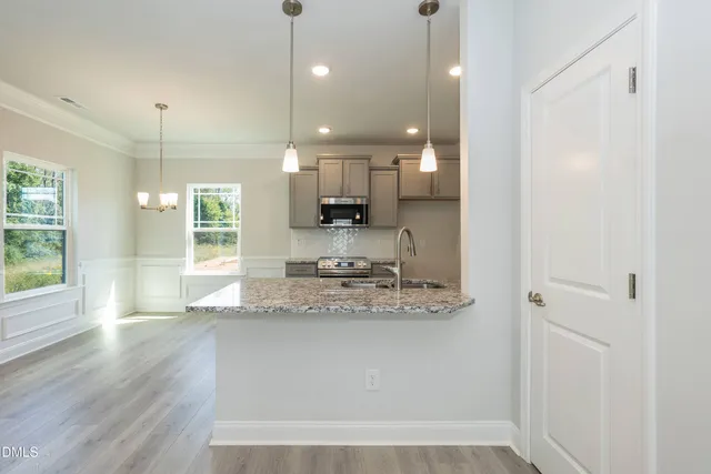 a view of a kitchen with a sink and wooden floor