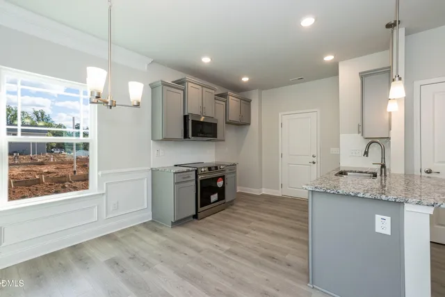 a kitchen with stainless steel appliances granite countertop a stove a sink and a refrigerator