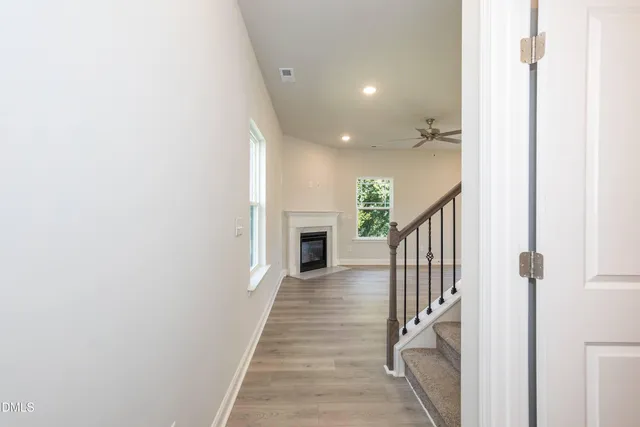 a view of a hallway with wooden floor and staircase
