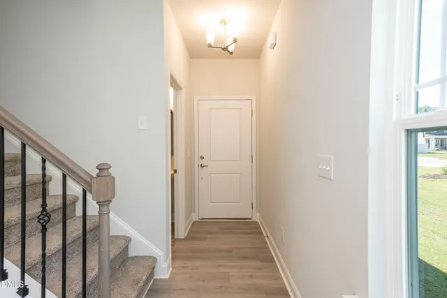 a view of a hallway with wooden floor and entryway