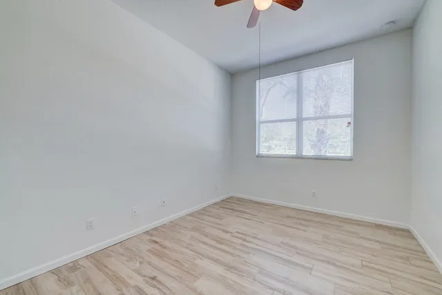 a view of an empty room and chandelier fan